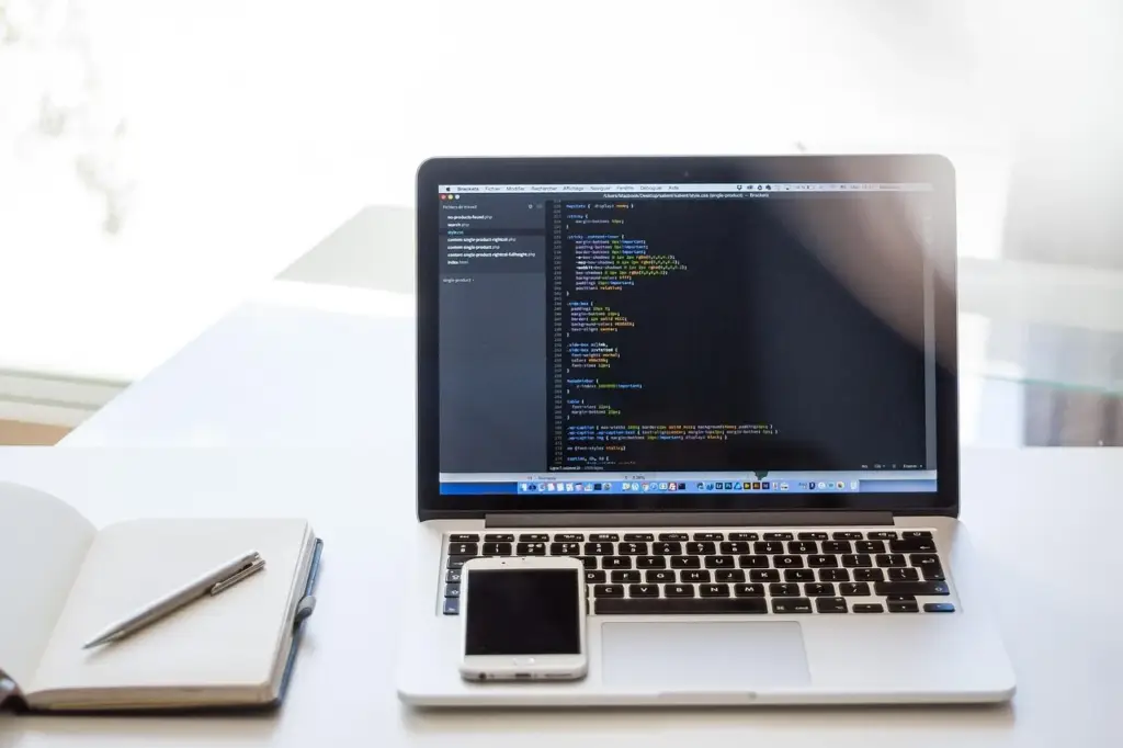 Developer reviewing code on a laptop at a desk