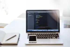 Developer reviewing code on a laptop at a desk