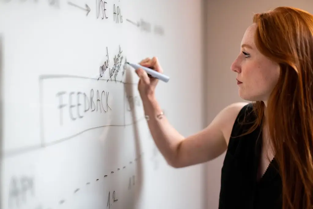 two software engineers planning on a whiteboard with database schema